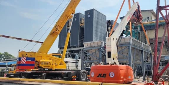 Mobile crane and boom lift available for rental at an industrial site